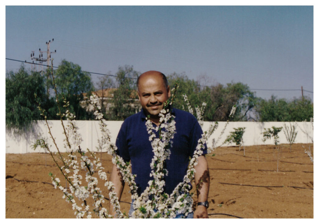 Salem Jarrar standing behind a tree on his first farm