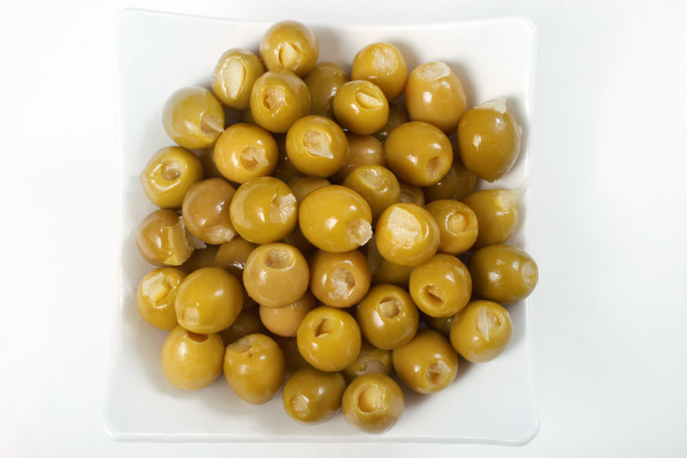 A white plate filled with lemon-stuffed green olives