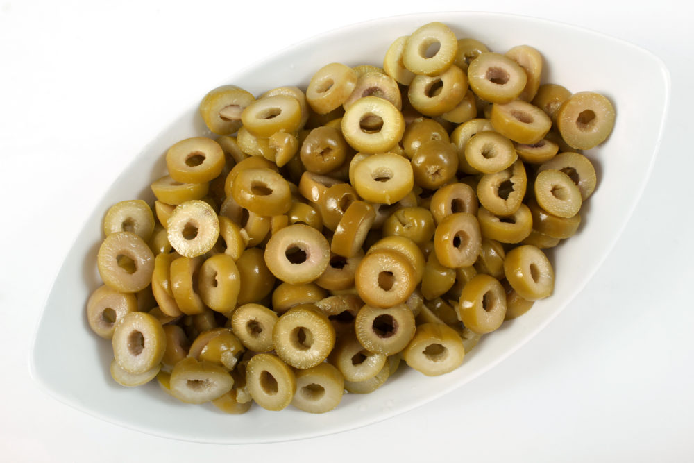 A white dish filled with slices of Spanish-style green olives